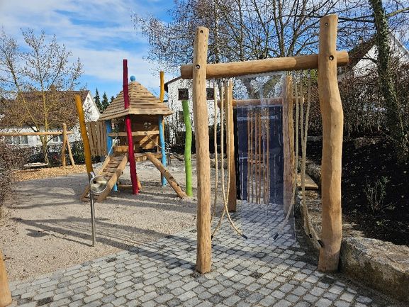 Sinnesbögen mit Kletterkombination und Korbnestschaukel im Hintergrund