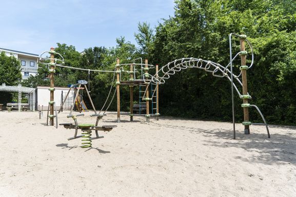 Blick über die vielseitige Kletteranlage. Im Hintergrund der gemütliche Sitzplatz für die Eltern